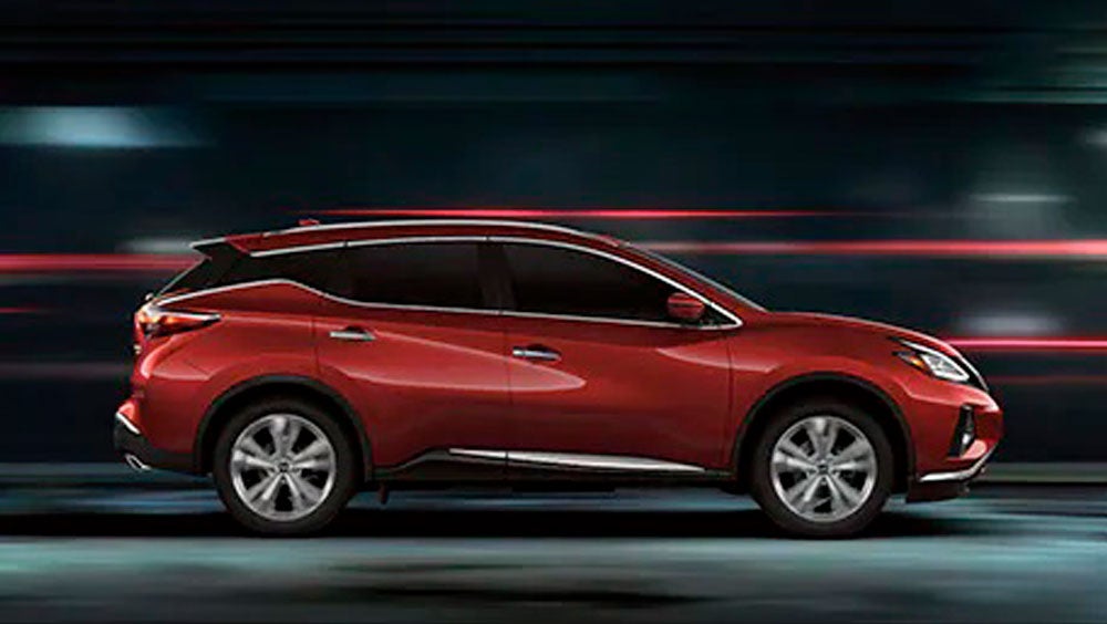 2023 Nissan Murano shown in profile driving down a street at night illustrating performance. | Valley Hi Nissan in Victorville CA